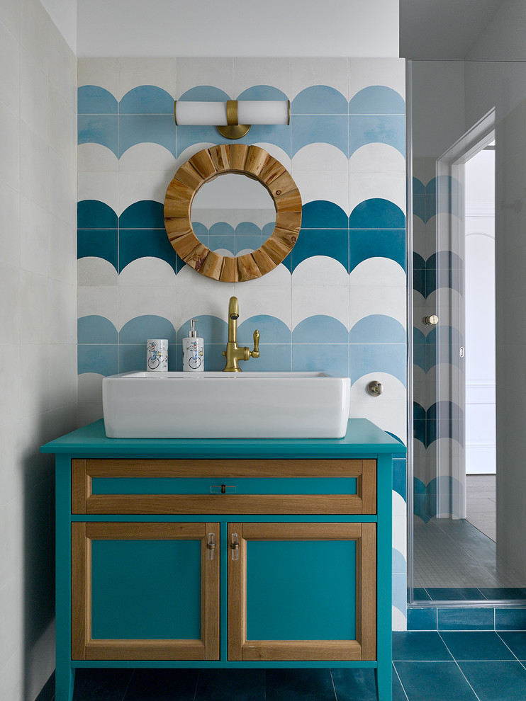 Inspiration pour une salle de bain design avec un placard avec porte à panneau encastré, des portes de placard turquoises, un carrelage bleu, un carrelage blanc, une vasque, un sol bleu et un plan de toilette turquoise.