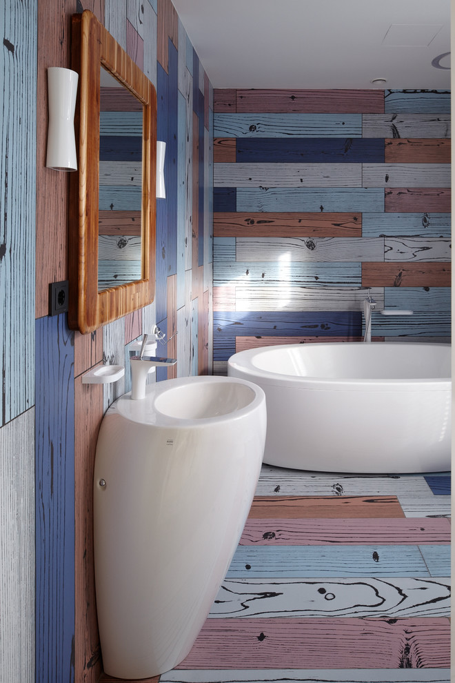 На фото: ванная комната в современном стиле с отдельно стоящей ванной, разноцветными стенами и раковиной с пьедесталом с
