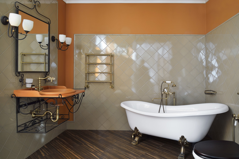 Свежая идея для дизайна: главная ванная комната в классическом стиле с ванной на ножках, раздельным унитазом, бежевой плиткой, оранжевыми стенами, накладной раковиной, коричневым полом и оранжевой столешницей - отличное фото интерьера