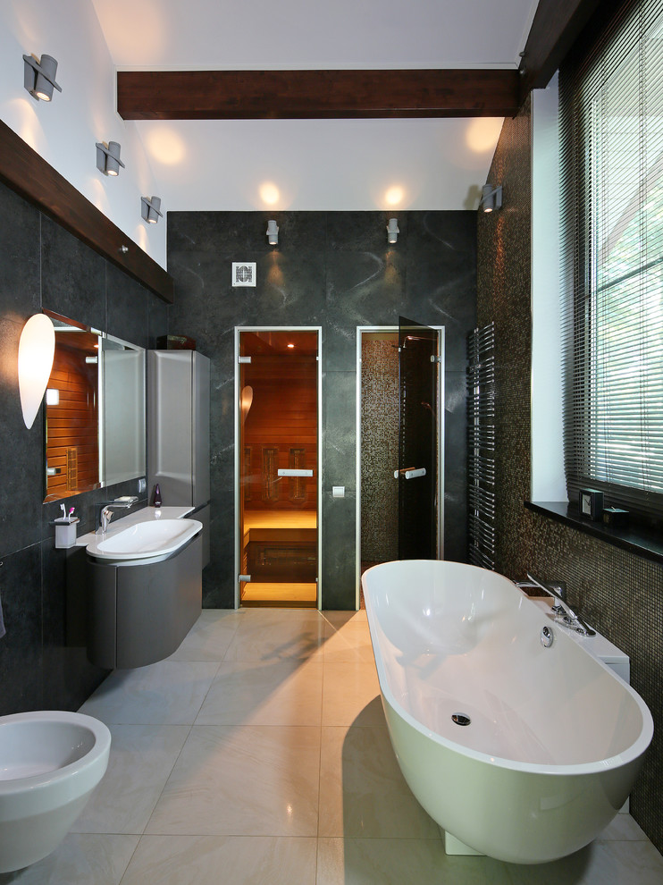 モスクワにあるコンテンポラリースタイルのおしゃれなマスターバスルーム (置き型浴槽、グレーのタイル、石スラブタイル、グレーのキャビネット、ビデ、黒い壁、一体型シンク、開き戸のシャワー) の写真