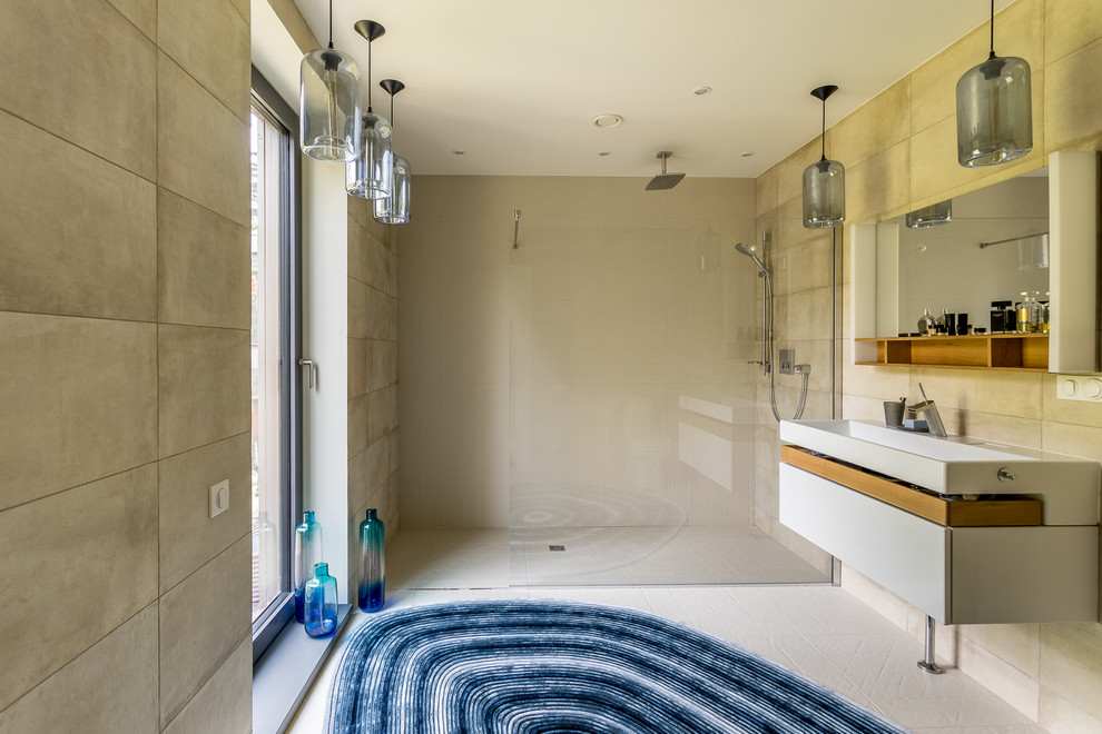 На фото: ванная комната среднего размера в скандинавском стиле с плоскими фасадами, белыми фасадами, душем без бортиков, бежевой плиткой, душевой кабиной, бежевыми стенами, консольной раковиной, бежевым полом и открытым душем