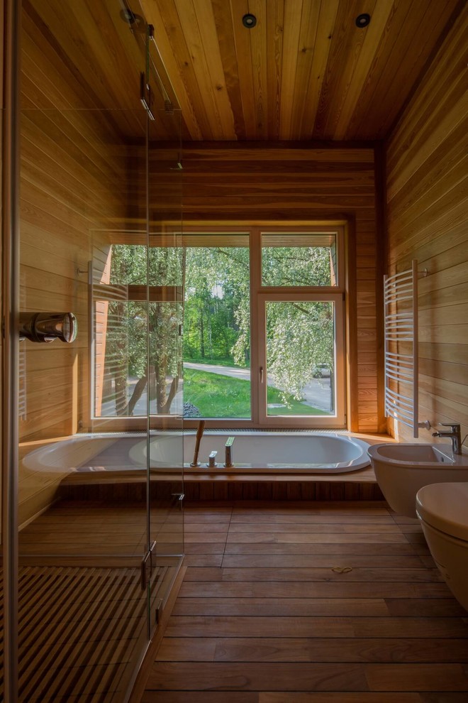 Cette photo montre une salle de bain principale tendance de taille moyenne avec un mur marron, parquet peint et une baignoire posée.