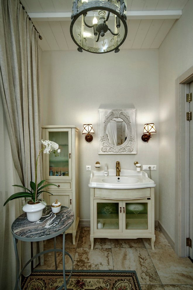 サンクトペテルブルクにあるシャビーシック調のおしゃれな浴室 (コンソール型シンク、ガラス扉のキャビネット、ベージュのキャビネット、石タイル、白い壁、大理石の床) の写真