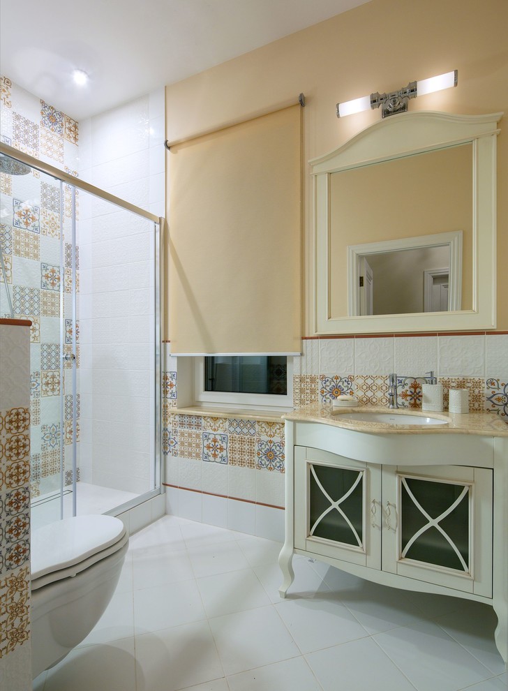Пример оригинального дизайна: ванная комната среднего размера в стиле неоклассика (современная классика) с душем в нише, инсталляцией, разноцветной плиткой, бежевыми стенами, душевой кабиной, врезной раковиной, белым полом, душем с раздвижными дверями и бежевой столешницей