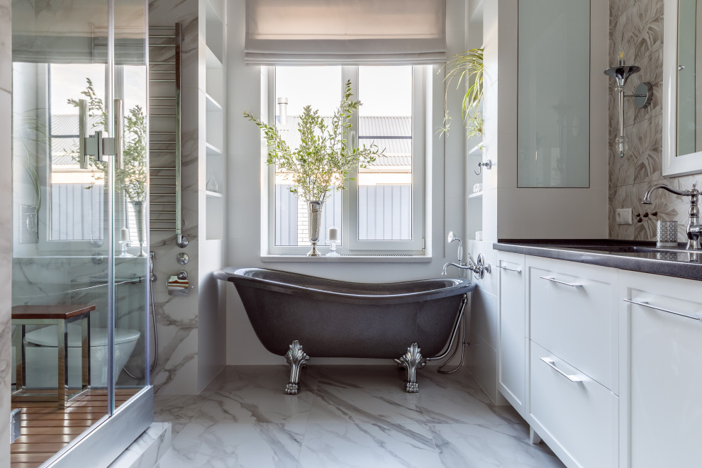 Foto de cuarto de baño a medida tradicional renovado grande con armarios estilo shaker, puertas de armario blancas, bañera con patas, ducha esquinera, baldosas y/o azulejos blancos, paredes blancas, lavabo bajoencimera, suelo blanco y encimeras grises