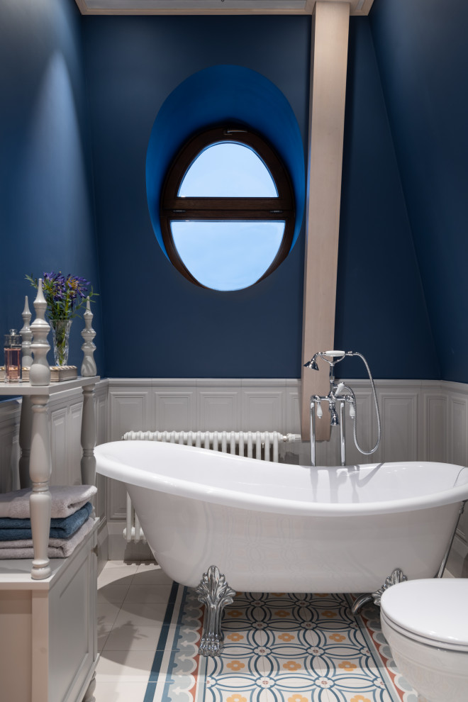 Стильный дизайн: главная ванная комната в стиле неоклассика (современная классика) с ванной на ножках, белой плиткой, синими стенами и разноцветным полом - последний тренд