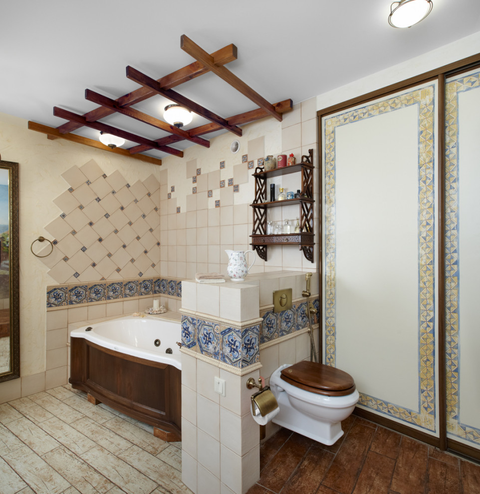 Пример оригинального дизайна: большой совмещенный санузел с темными деревянными фасадами, ванной в нише и бежевой плиткой