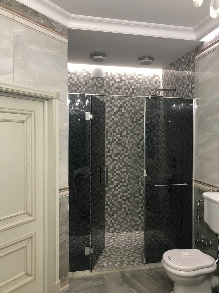 Aménagement d'une salle de bain classique de taille moyenne avec un placard à porte vitrée, des portes de placard grises, un mur beige et une cabine de douche à porte battante.