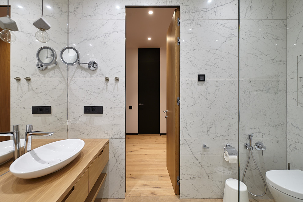 Idée de décoration pour une salle de bain avec des portes de placard beiges, un carrelage gris, des toilettes cachées, meuble simple vasque et meuble-lavabo suspendu.