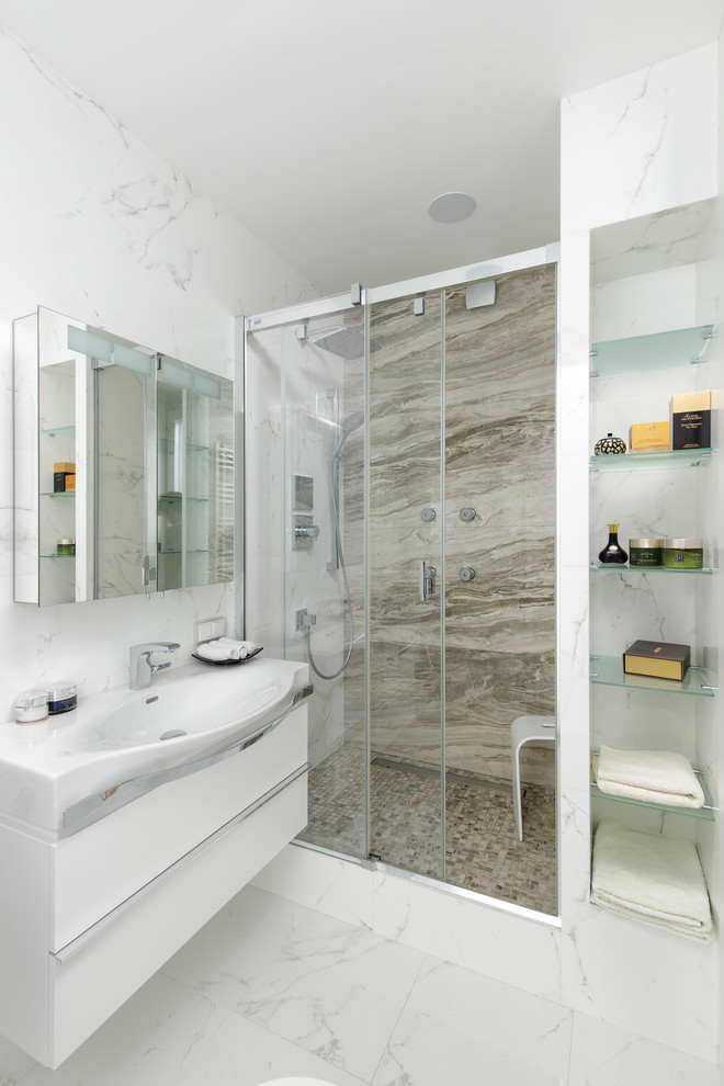 Стильный дизайн: ванная комната в современном стиле с плоскими фасадами, белыми фасадами, душем в нише, душевой кабиной, белым полом, разноцветной плиткой, плиткой из листового камня, белыми стенами, душем с раздвижными дверями, унитазом-моноблоком, полом из керамогранита и настольной раковиной - последний тренд