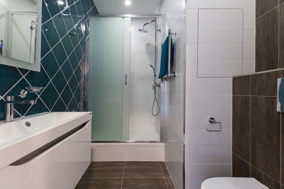 Пример оригинального дизайна: ванная комната среднего размера в скандинавском стиле с плоскими фасадами, белыми фасадами, душем в нише, инсталляцией, зеленой плиткой, керамической плиткой, белыми стенами, полом из керамической плитки, душевой кабиной, накладной раковиной, столешницей из искусственного камня, душем с раздвижными дверями, белой столешницей и коричневым полом