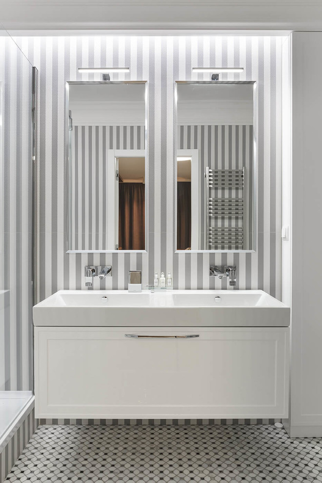 На фото: большая ванная комната в современном стиле с фасадами с утопленной филенкой, белыми фасадами, душевой кабиной, раковиной с несколькими смесителями и серым полом