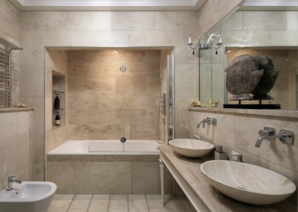 Idéer för stora vintage beige en-suite badrum, med ett badkar i en alkov, en dusch/badkar-kombination, en bidé, beige kakel, travertinkakel, travertin golv, marmorbänkskiva, beiget golv och ett fristående handfat