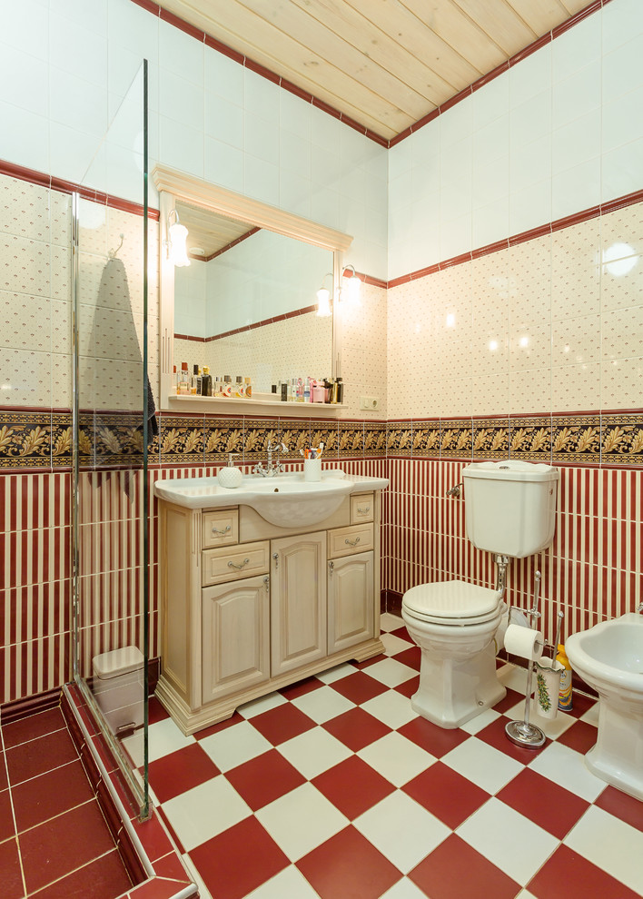 Foto på ett vintage badrum med dusch, med luckor med upphöjd panel, en toalettstol med separat cisternkåpa, röd kakel, flerfärgad kakel, skåp i ljust trä och med dusch som är öppen