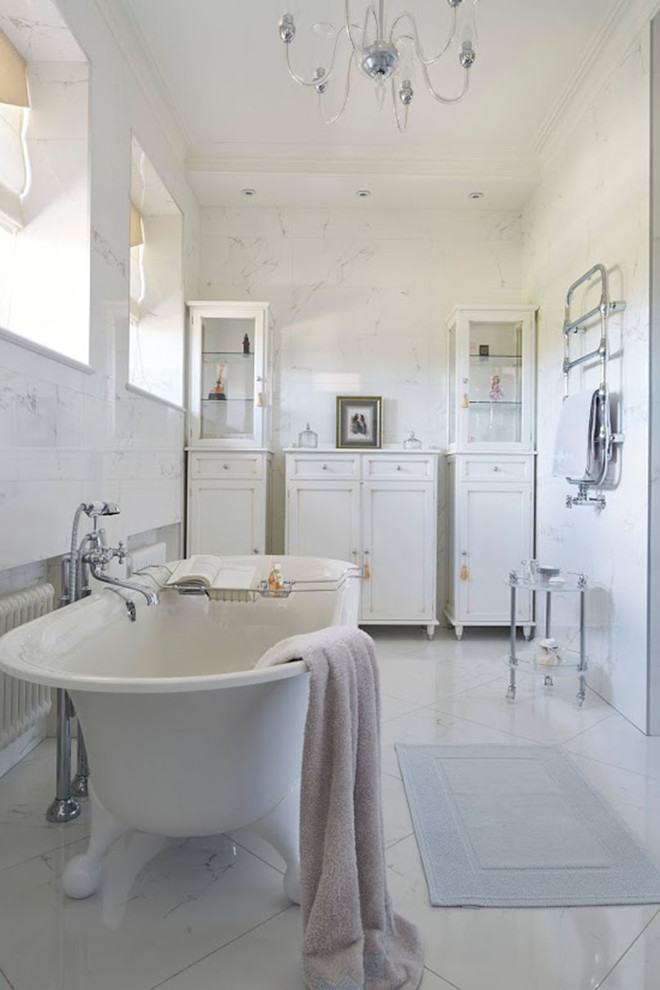 На фото: ванная комната в стиле неоклассика (современная классика) с ванной на ножках, белой плиткой и белым полом