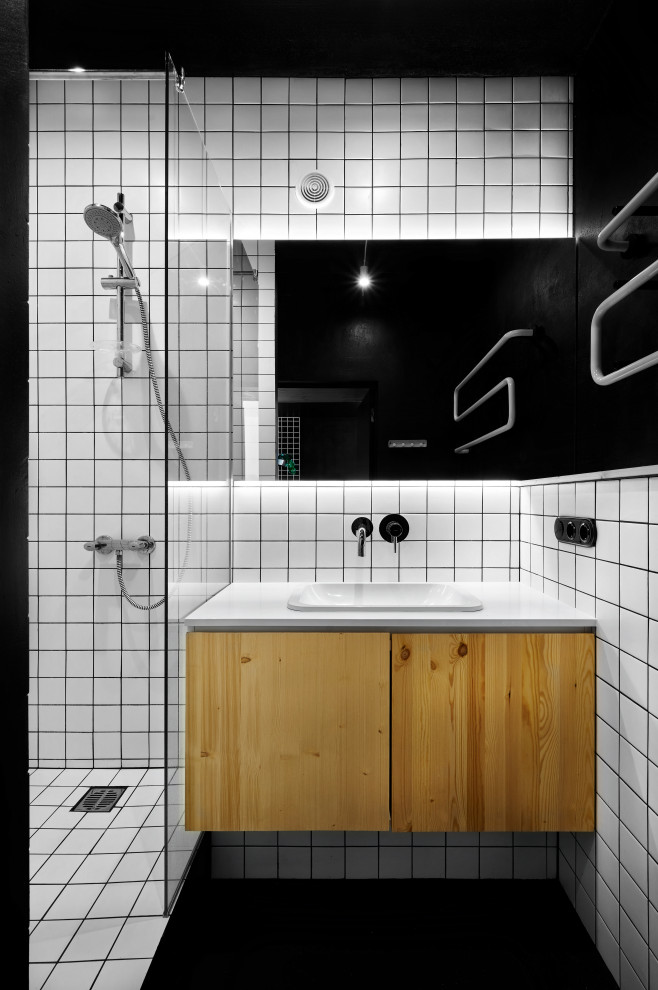Diseño de cuarto de baño único y flotante urbano con armarios con paneles lisos, puertas de armario de madera oscura, ducha empotrada, baldosas y/o azulejos blancos, paredes negras, aseo y ducha, lavabo encastrado, suelo negro y encimeras blancas
