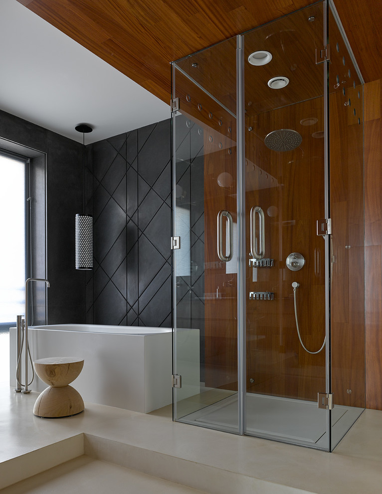 Inredning av ett modernt mellanstort en-suite badrum, med ett fristående badkar, en kantlös dusch, svart kakel, betonggolv, beiget golv och dusch med gångjärnsdörr