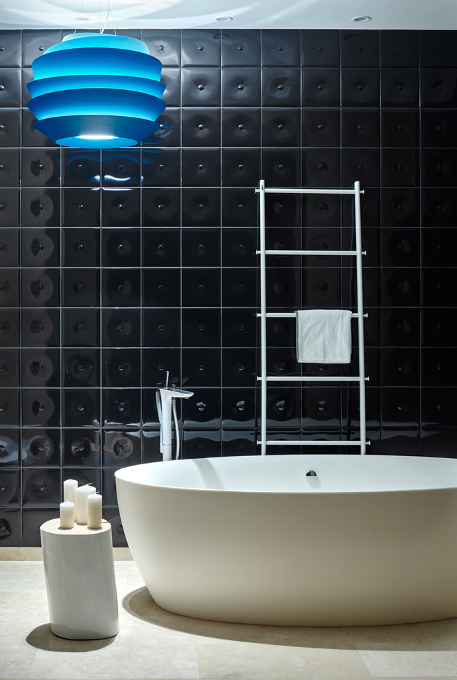 Стильный дизайн: главная ванная комната среднего размера в современном стиле с отдельно стоящей ванной, черной плиткой, керамической плиткой, полом из травертина и черными стенами - последний тренд