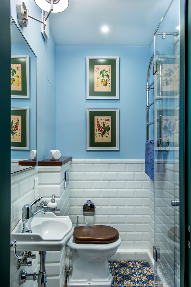Идея дизайна: ванная комната в стиле неоклассика (современная классика) с раздельным унитазом, белой плиткой, плиткой кабанчик, синими стенами, душевой кабиной, подвесной раковиной, душем с распашными дверями и разноцветным полом