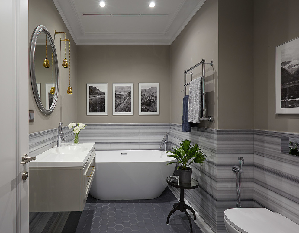 На фото: главная ванная комната в современном стиле с отдельно стоящей ванной, серой плиткой, разноцветной плиткой, белой плиткой, бежевыми стенами, монолитной раковиной, серым полом, белой столешницей, плоскими фасадами и серыми фасадами