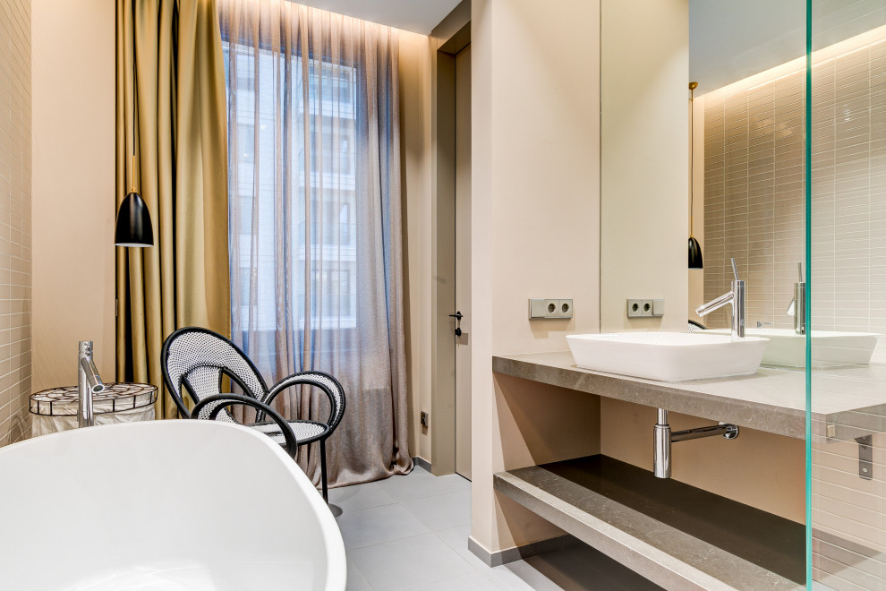 Стильный дизайн: ванная комната среднего размера в современном стиле с открытыми фасадами, серыми фасадами, отдельно стоящей ванной, бежевой плиткой, плиткой мозаикой, бежевыми стенами, настольной раковиной, серым полом и серой столешницей - последний тренд