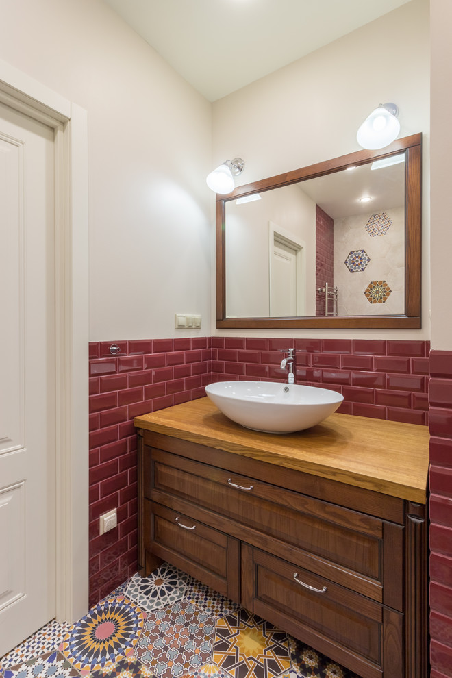 Idées déco pour une salle de bain classique en bois foncé avec un carrelage rouge, un carrelage métro, un mur beige, une vasque, un plan de toilette en bois, un sol multicolore, un plan de toilette beige et un placard avec porte à panneau encastré.