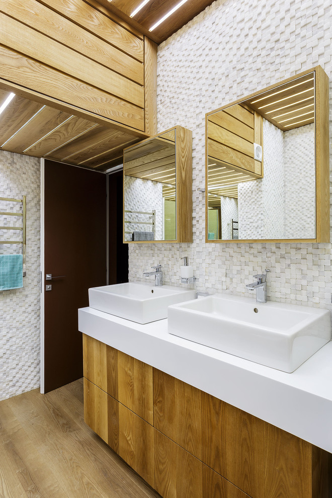 Idee per una stanza da bagno minimal di medie dimensioni con piastrelle bianche, pareti bianche, top in superficie solida, top bianco, ante lisce, ante in legno scuro, piastrelle a mosaico, lavabo a bacinella e pavimento beige