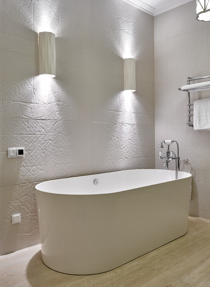 На фото: главная ванная комната в современном стиле с отдельно стоящей ванной и белой плиткой