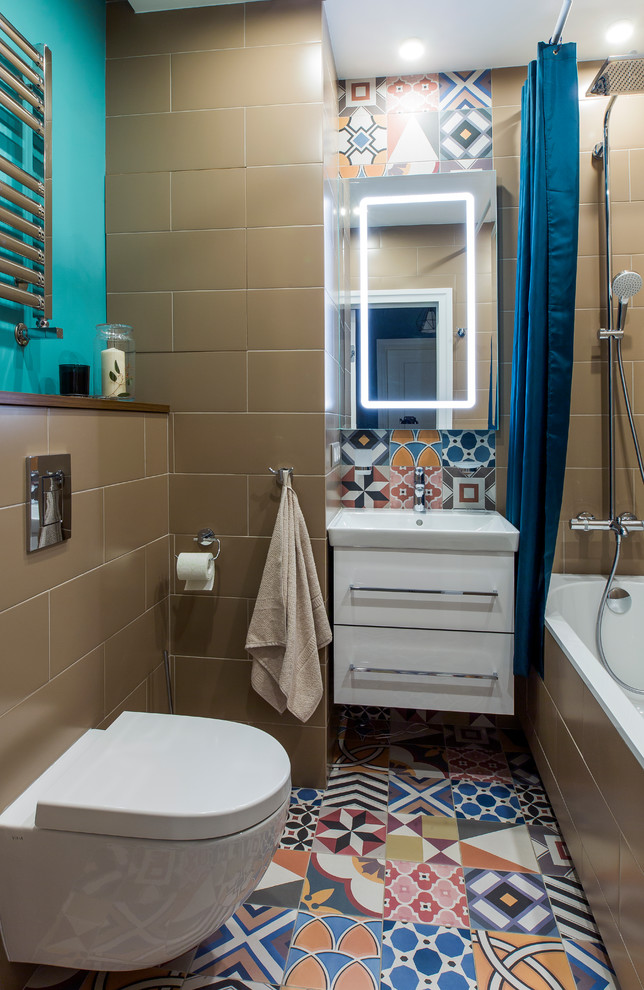 Idée de décoration pour une salle de bain principale design avec un placard à porte plane, des portes de placard blanches, une baignoire en alcôve, WC suspendus, un lavabo intégré et un sol multicolore.