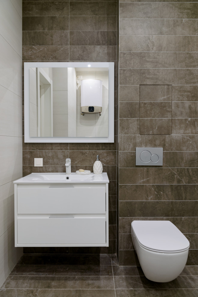Свежая идея для дизайна: ванная комната среднего размера в современном стиле с плоскими фасадами, белыми фасадами, серой плиткой, керамогранитной плиткой, полом из керамогранита, душевой кабиной, монолитной раковиной, серым полом и белой столешницей - отличное фото интерьера