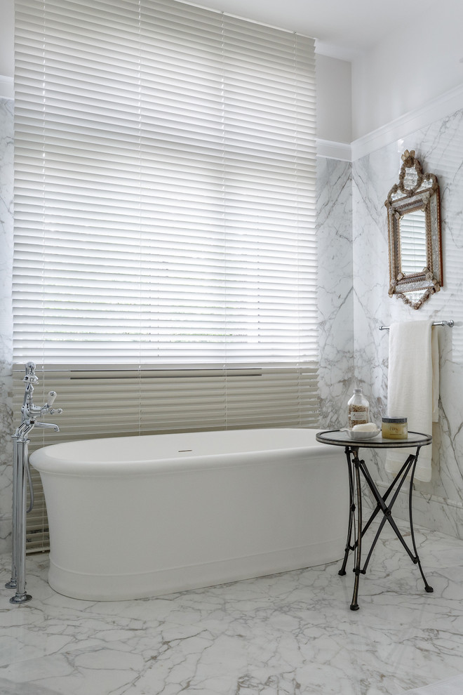 Foto di una stanza da bagno chic con vasca freestanding, piastrelle bianche, piastrelle grigie, lastra di pietra e pareti bianche