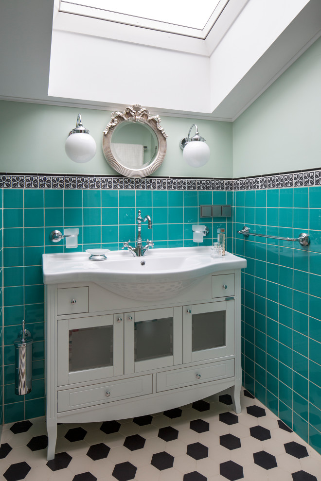 Diseño de cuarto de baño actual con armarios tipo vitrina, puertas de armario blancas, paredes verdes, lavabo integrado y suelo multicolor