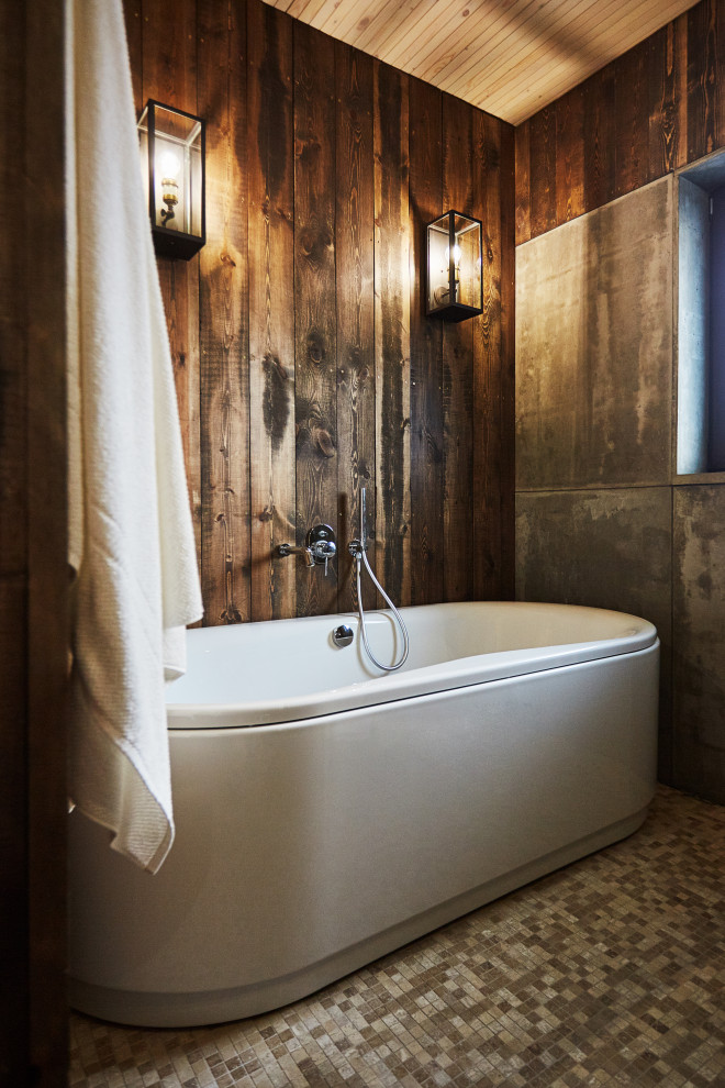Modelo de cuarto de baño principal rústico de tamaño medio con bañera exenta, paredes marrones, suelo gris, madera y madera