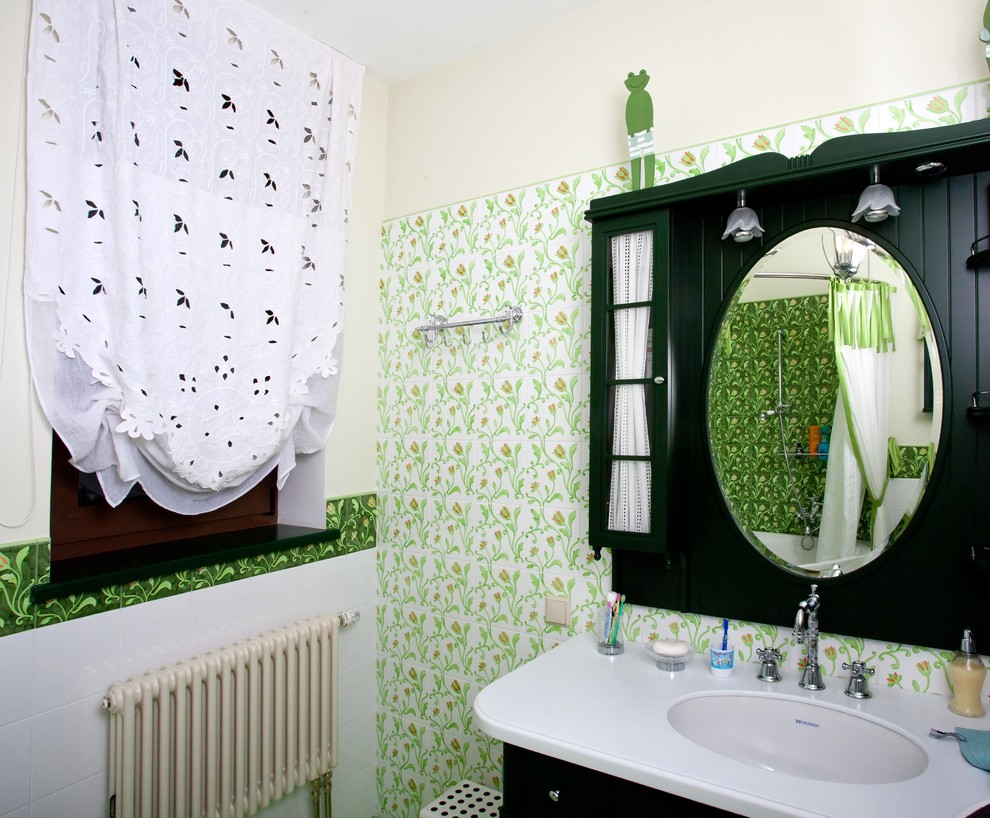 Cette photo montre une salle de bain principale chic avec un combiné douche/baignoire, des carreaux de céramique, des portes de placard noires, un carrelage vert et une vasque.