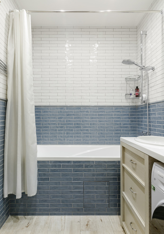 Immagine di una stanza da bagno padronale minimal con ante con riquadro incassato, ante beige, vasca ad alcova, piastrelle blu, piastrelle bianche, lavabo da incasso, pavimento beige, doccia con tenda e top bianco