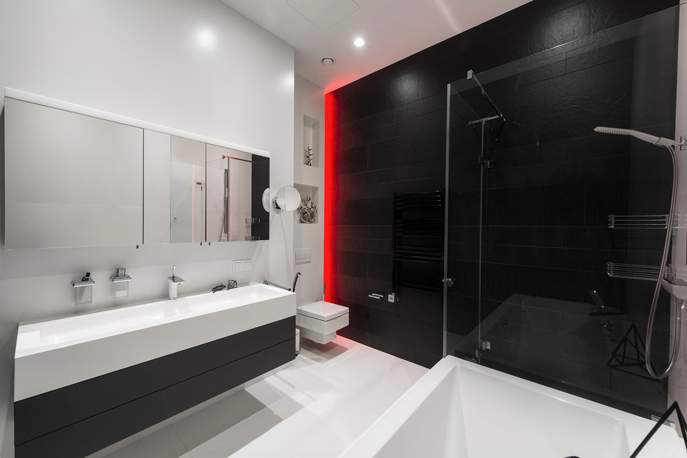 Aménagement d'une salle de bain contemporaine avec une baignoire indépendante, une douche d'angle, WC suspendus, un mur blanc et un lavabo intégré.