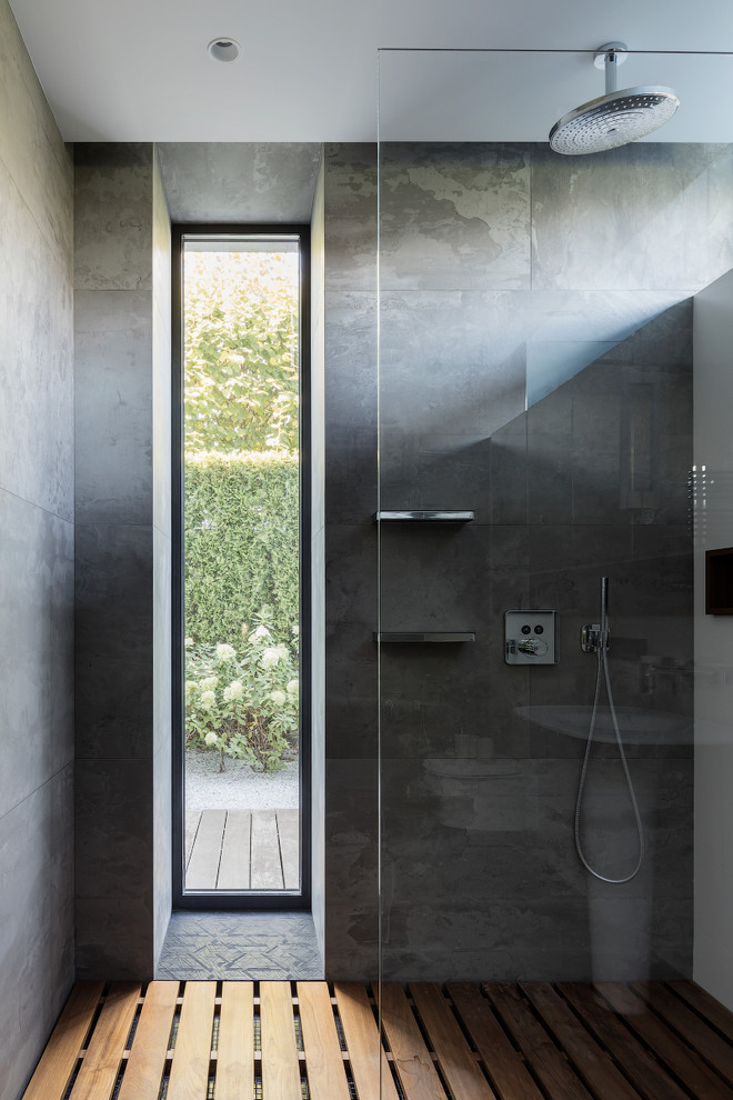 Modelo de cuarto de baño contemporáneo con baldosas y/o azulejos grises y aseo y ducha