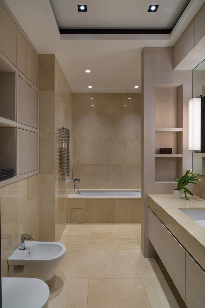 Idéer för stora funkis badrum, med släta luckor, skåp i ljust trä, ett undermonterat badkar, beige kakel, stenhäll, beige väggar, travertin golv, ett undermonterad handfat, marmorbänkskiva, en dusch/badkar-kombination, en bidé och beiget golv