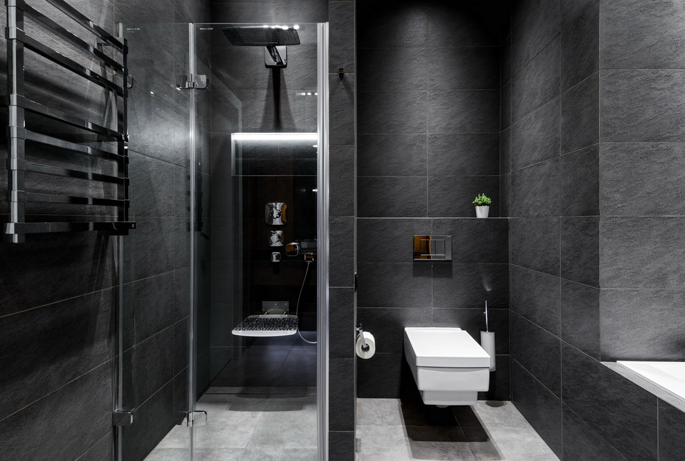 Modelo de cuarto de baño principal actual con bañera empotrada, ducha empotrada, sanitario de pared, baldosas y/o azulejos grises y ducha con puerta con bisagras