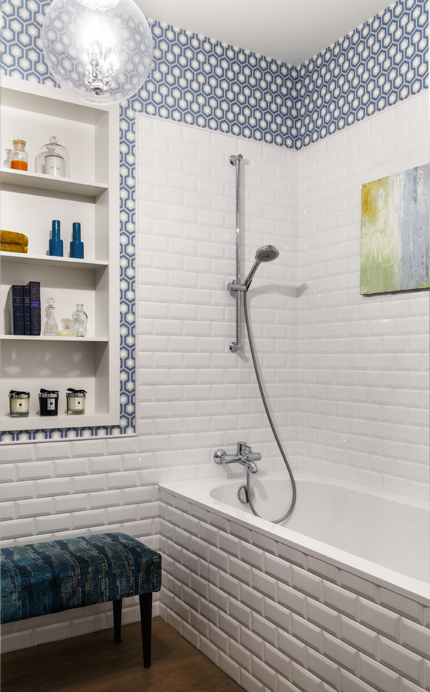 Cette photo montre une salle de bain principale chic avec une baignoire en alcôve, un combiné douche/baignoire, un carrelage blanc, un carrelage métro, un mur bleu et un sol marron.