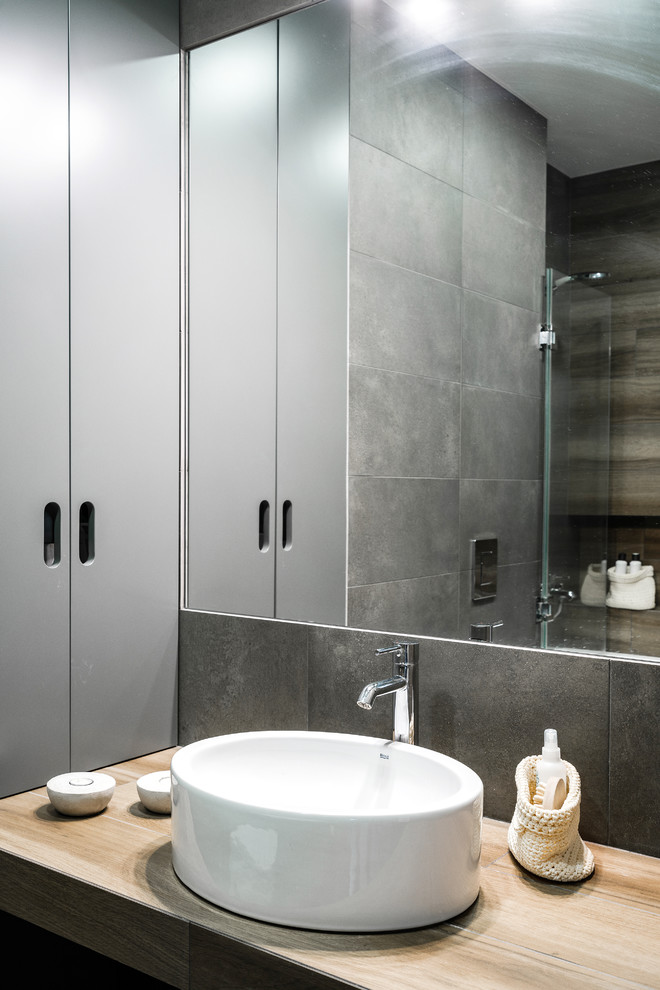 Пример оригинального дизайна: главная ванная комната в скандинавском стиле с серой плиткой и настольной раковиной