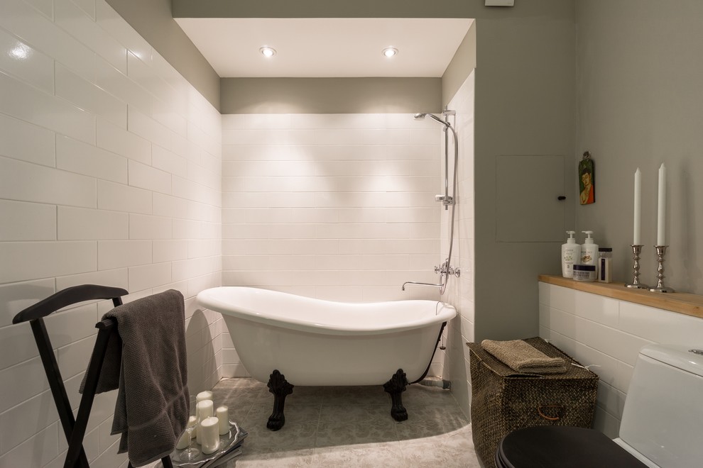Ispirazione per una grande stanza da bagno padronale minimal con vasca freestanding, WC monopezzo, piastrelle bianche, piastrelle in ceramica e pareti grigie
