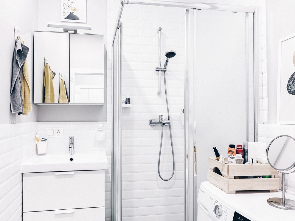 Modelo de cuarto de baño escandinavo pequeño con puertas de armario blancas, ducha empotrada, baldosas y/o azulejos blancos, aseo y ducha, ducha con puerta corredera y encimeras blancas
