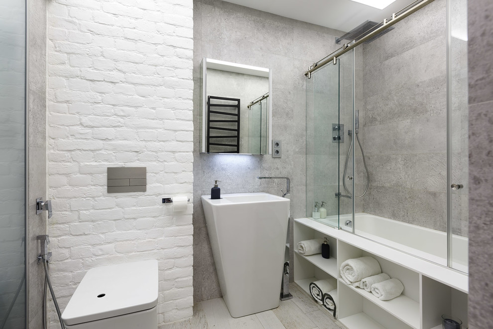 Cette photo montre une salle de bain industrielle avec un combiné douche/baignoire, un mur gris, un lavabo de ferme, une baignoire posée et une cabine de douche à porte coulissante.