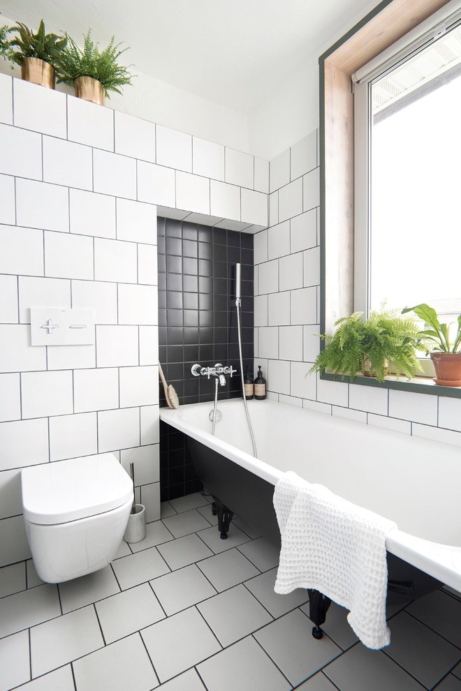 Design ideas for a small industrial ensuite bathroom in Saint Petersburg with a claw-foot bath, a shower/bath combination, a wall mounted toilet, white tiles, ceramic tiles, white walls, ceramic flooring and white floors.