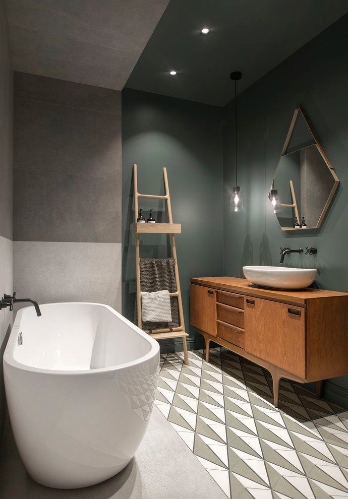 Large danish master gray tile and porcelain tile cement tile floor and multicolored floor freestanding bathtub photo in Saint Petersburg with green walls, a vessel sink, wood countertops, medium tone wood cabinets, flat-panel cabinets and brown countertops