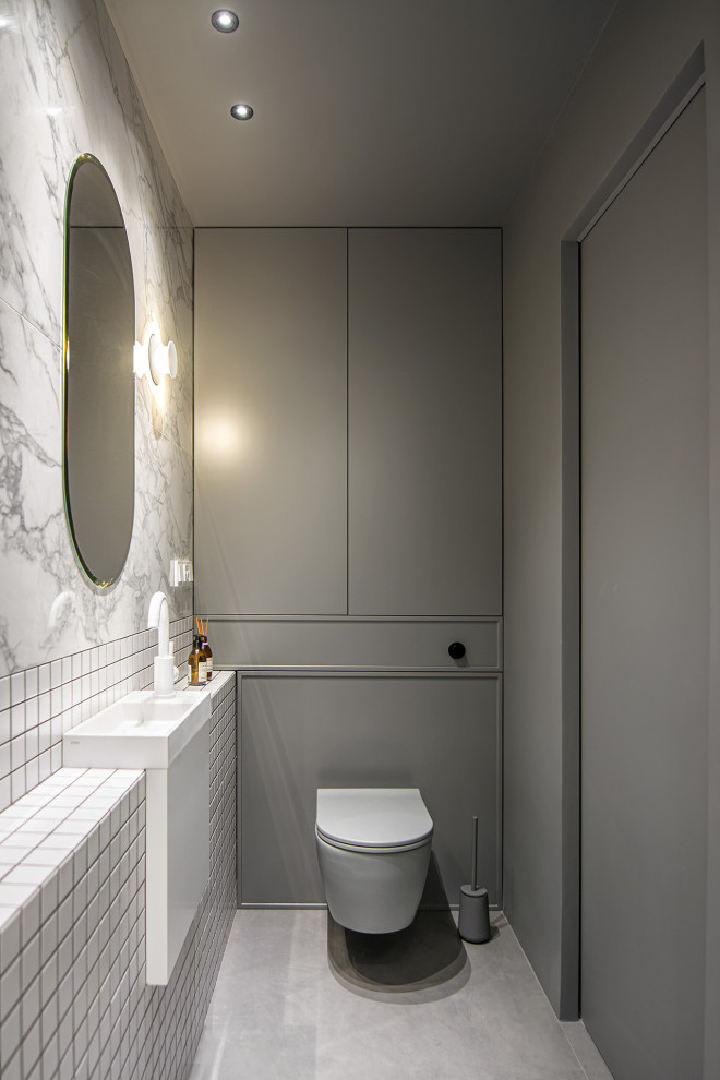 Свежая идея для дизайна: маленькая ванная комната в современном стиле с фасадами с декоративным кантом, серыми фасадами, отдельно стоящей ванной, душем в нише, инсталляцией, белой плиткой, керамической плиткой, серыми стенами, полом из керамогранита, душевой кабиной, настольной раковиной, серым полом, душем с распашными дверями, тумбой под одну раковину и подвесной тумбой для на участке и в саду - отличное фото интерьера