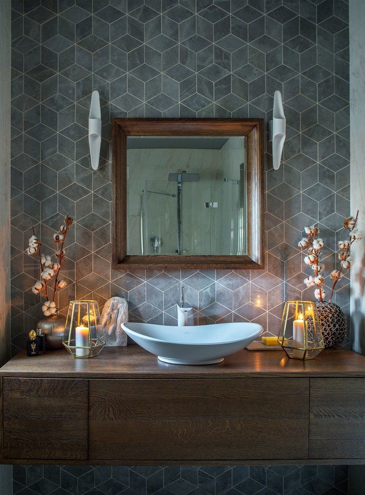 Bathroom - contemporary gray tile bathroom idea in Moscow with flat-panel cabinets, dark wood cabinets, a vessel sink, wood countertops, brown countertops, gray walls and a hinged shower door
