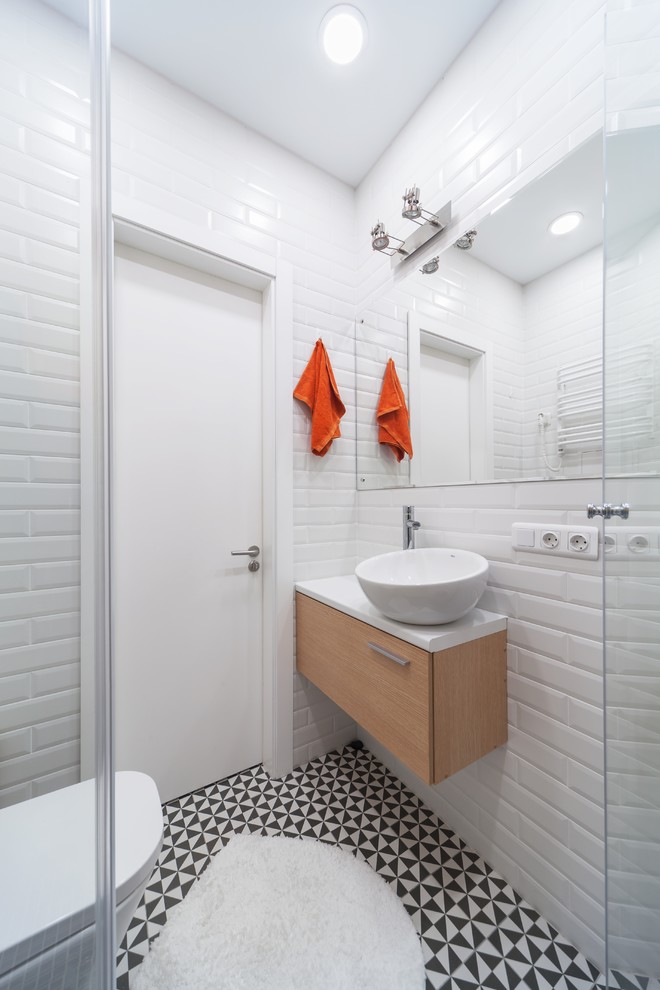 На фото: маленькая ванная комната в современном стиле с белой плиткой, полом из керамогранита, плиткой кабанчик, настольной раковиной, плоскими фасадами, белыми стенами и разноцветным полом для на участке и в саду с