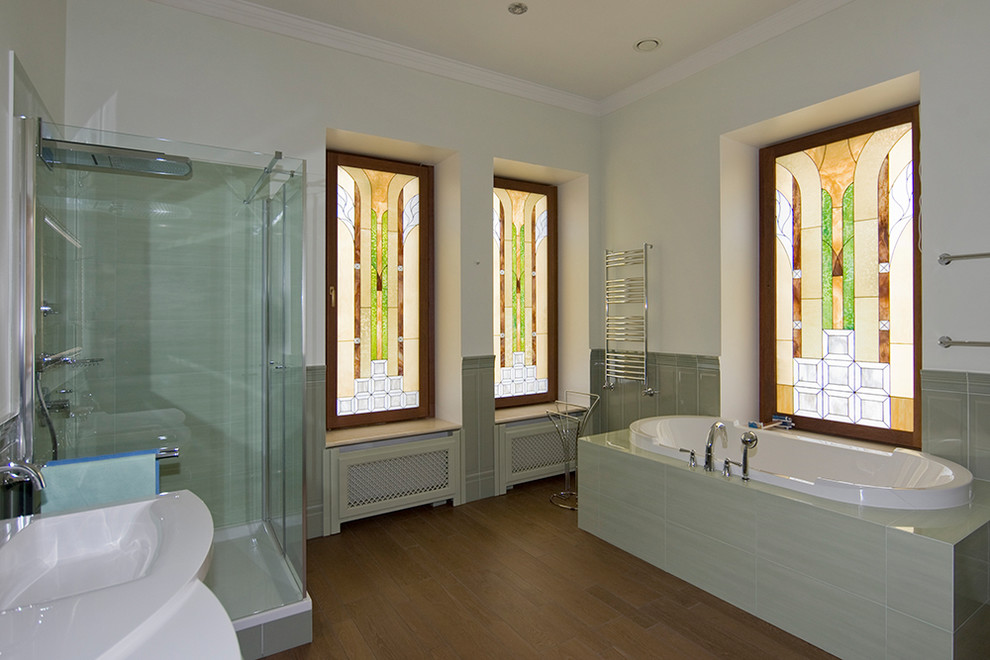 Large classic ensuite bathroom in Moscow with medium wood cabinets, a submerged bath, a corner shower, a one-piece toilet, green tiles, ceramic tiles, green walls, porcelain flooring and a built-in sink.